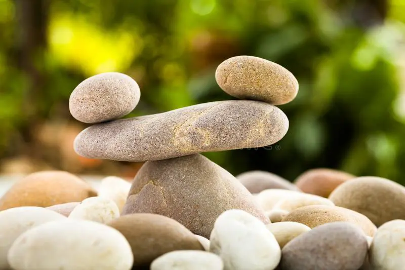 two stones placed on one big flat stone for balancing